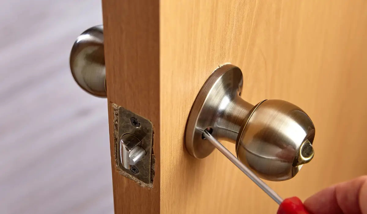 Removing a door knob by pressing the release pin with a small tool