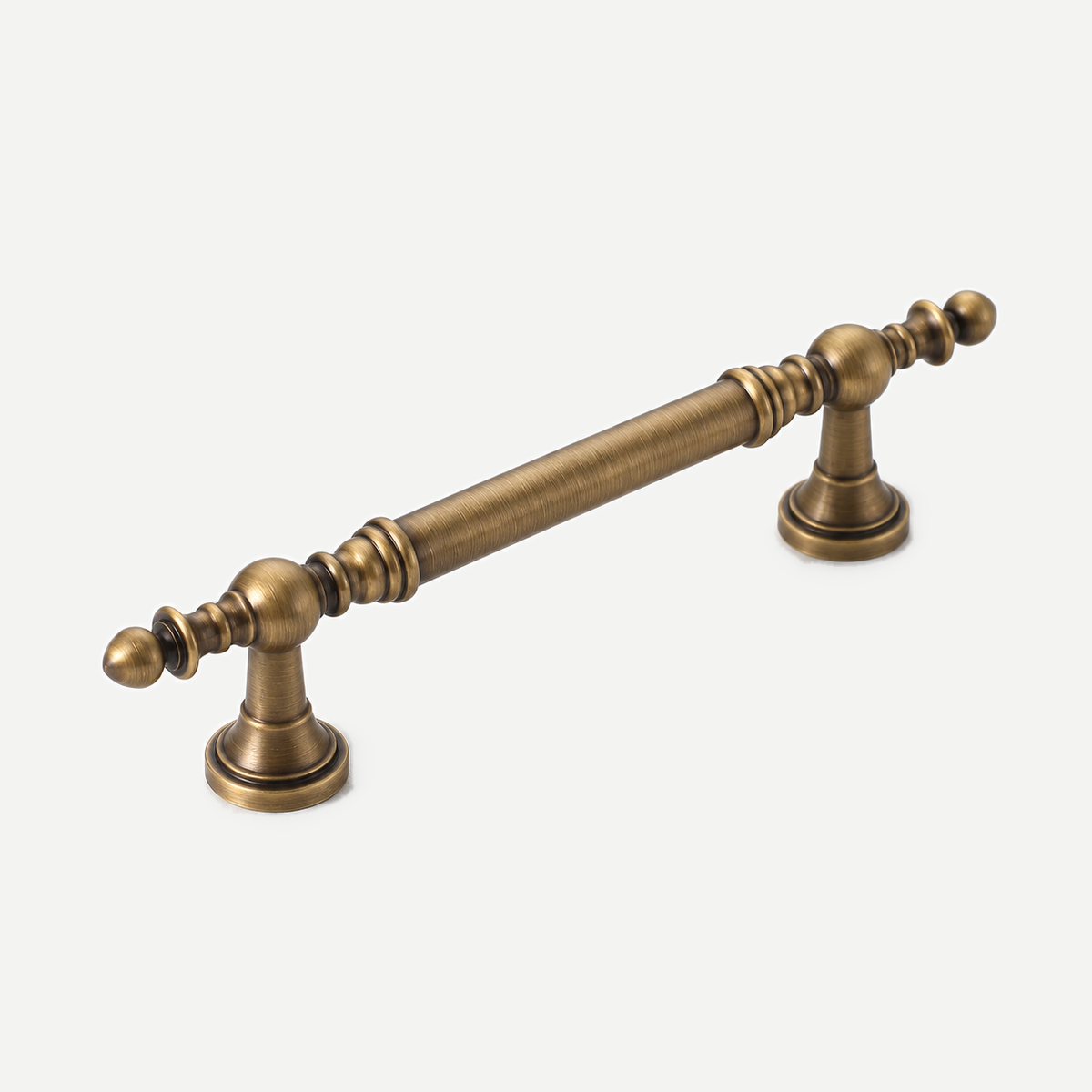 Antique bronze brass cabinet handle — complete diagonal view of turned ends and two mounting feet