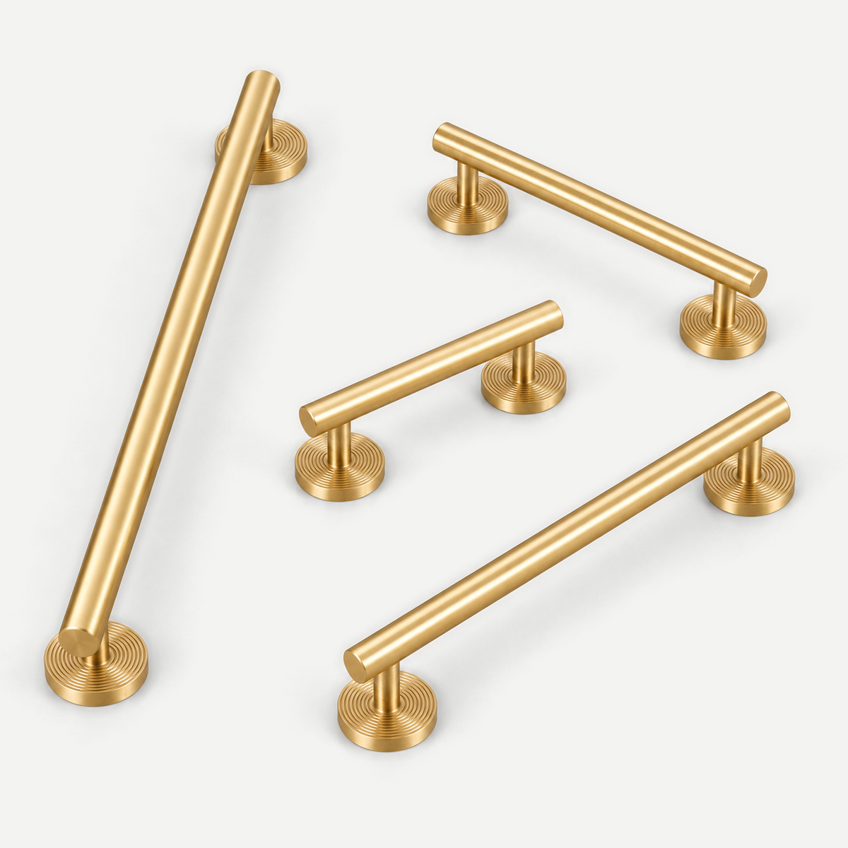 Brushed brass smooth cabinet handles with machined round disc bases — all four sizes in an asymmetric portrait layout