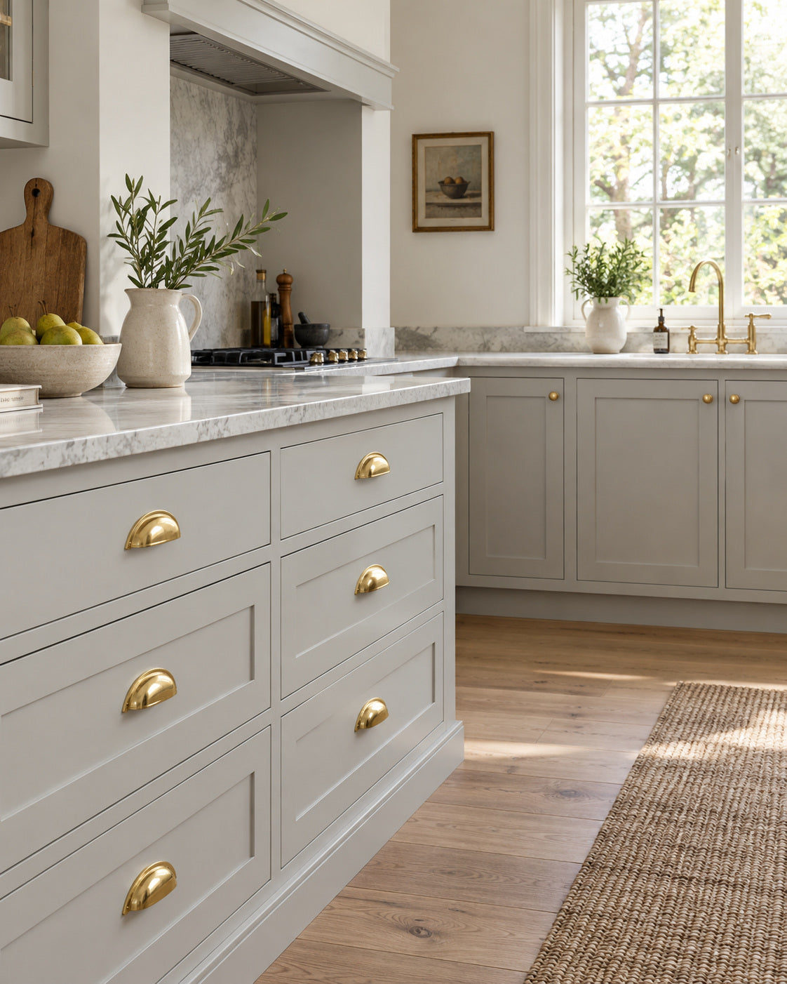 Brass cup pulls fitted to grey kitchen cabinetry